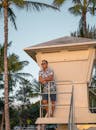 Tanned man in sunglasses standing on safeguard tower