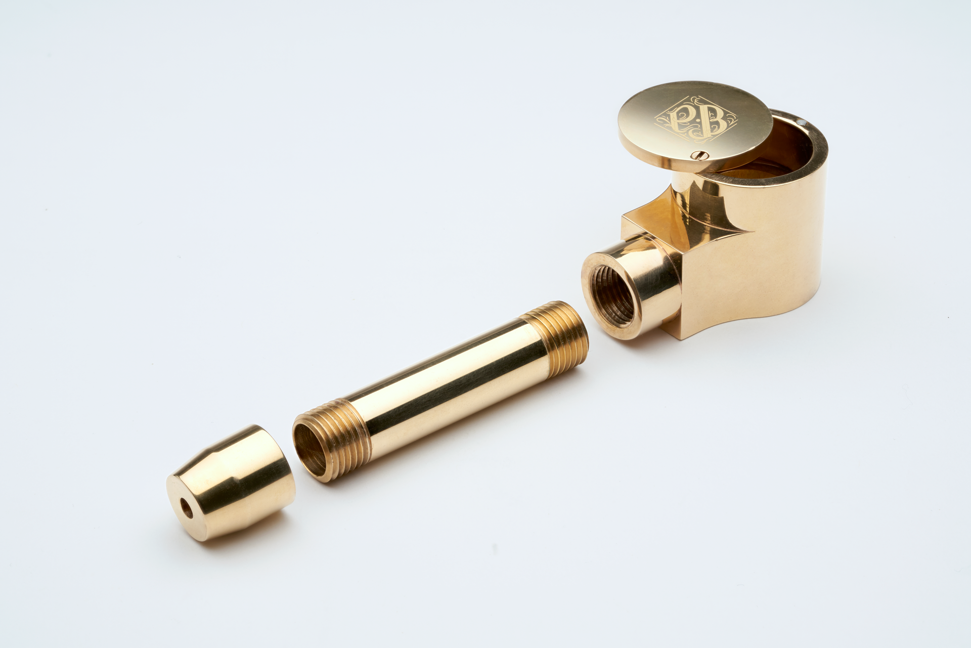 Sleek brass tobacco pipe disassembled on a clean white background.
