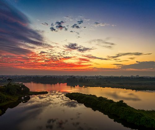 Free Stunning sunset reflection over a peaceful lake with a dramatic sky in Banten, Indonesia. Stock Photo