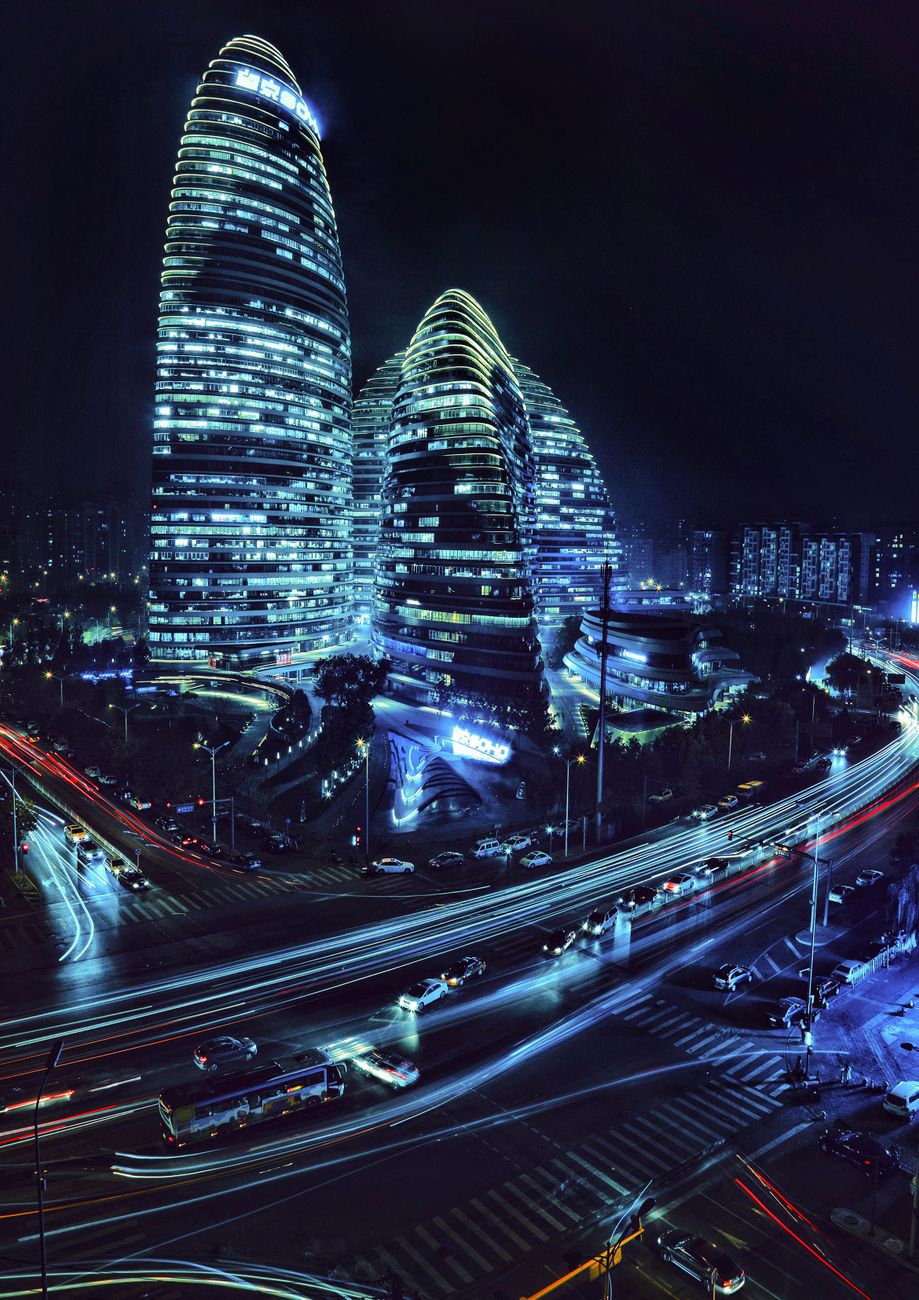 cinematic aerial view of a futuristic Asian city at night with glowing blue and purple skyscrapers and neon street lights, vertical photograph
