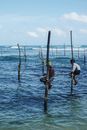 Man in White Shirt Holding Brown Wooden Stick on Body of Water