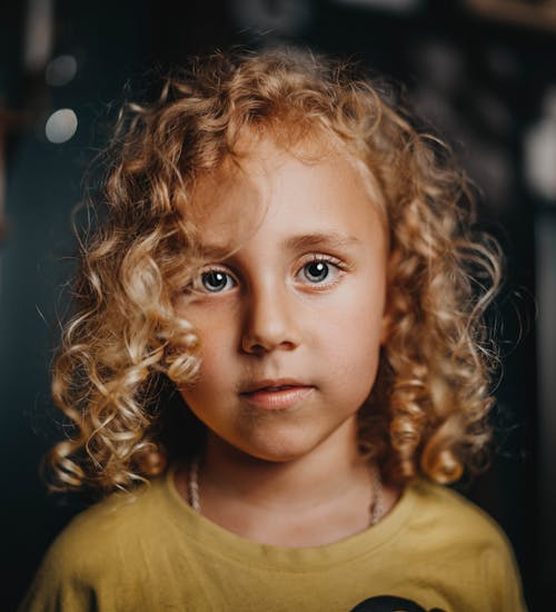 Portrait of a Girl With Beautiful Eyes and Blonde Curly Hair