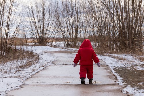 Free A Child Wearing Red Jacket Walking on the Concrete Pavement Stock Photo