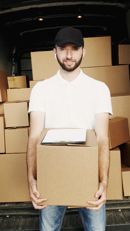 Free Man in White Polo Shirt Holding a Carton Box Stock Photo