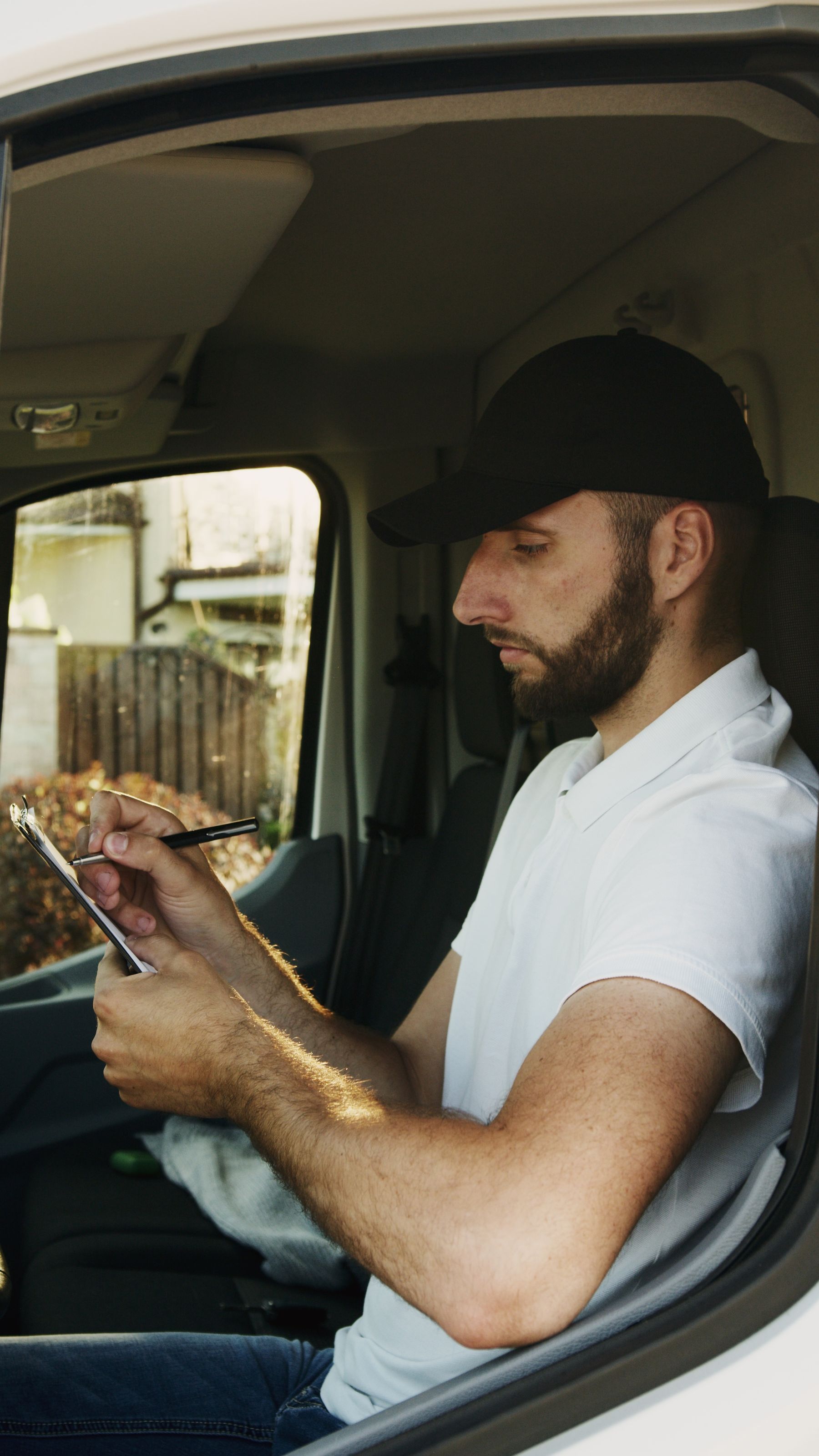 Professional driver reviewing records on a clipboard inside a commercial vehicle
