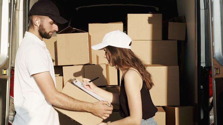 Woman Receiving The Package From The Deliveryman