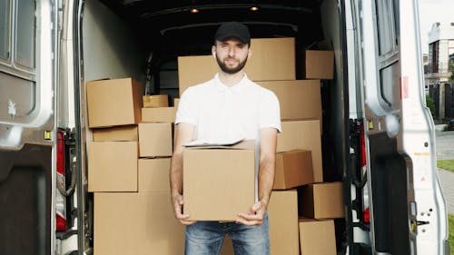 Free Man Smiling while Holding a Box Stock Photo