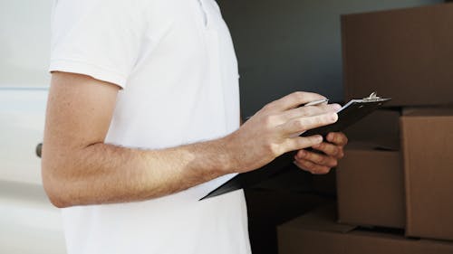 Man in White T-shirt Holding Black Clipboard