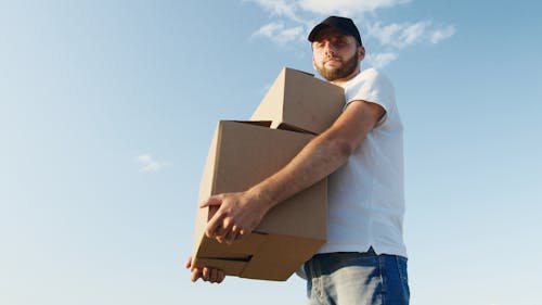 Man in White Shirt Carrying Cardboard Boxes