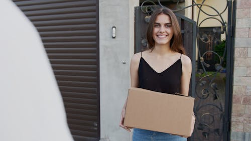 Woman in Black Tank Top Holding a Box