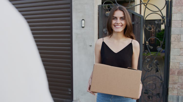 Woman In Black Tank Top Holding A Box