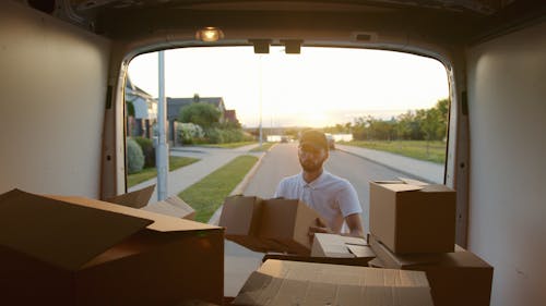 Man Putting Boxes Inside a van