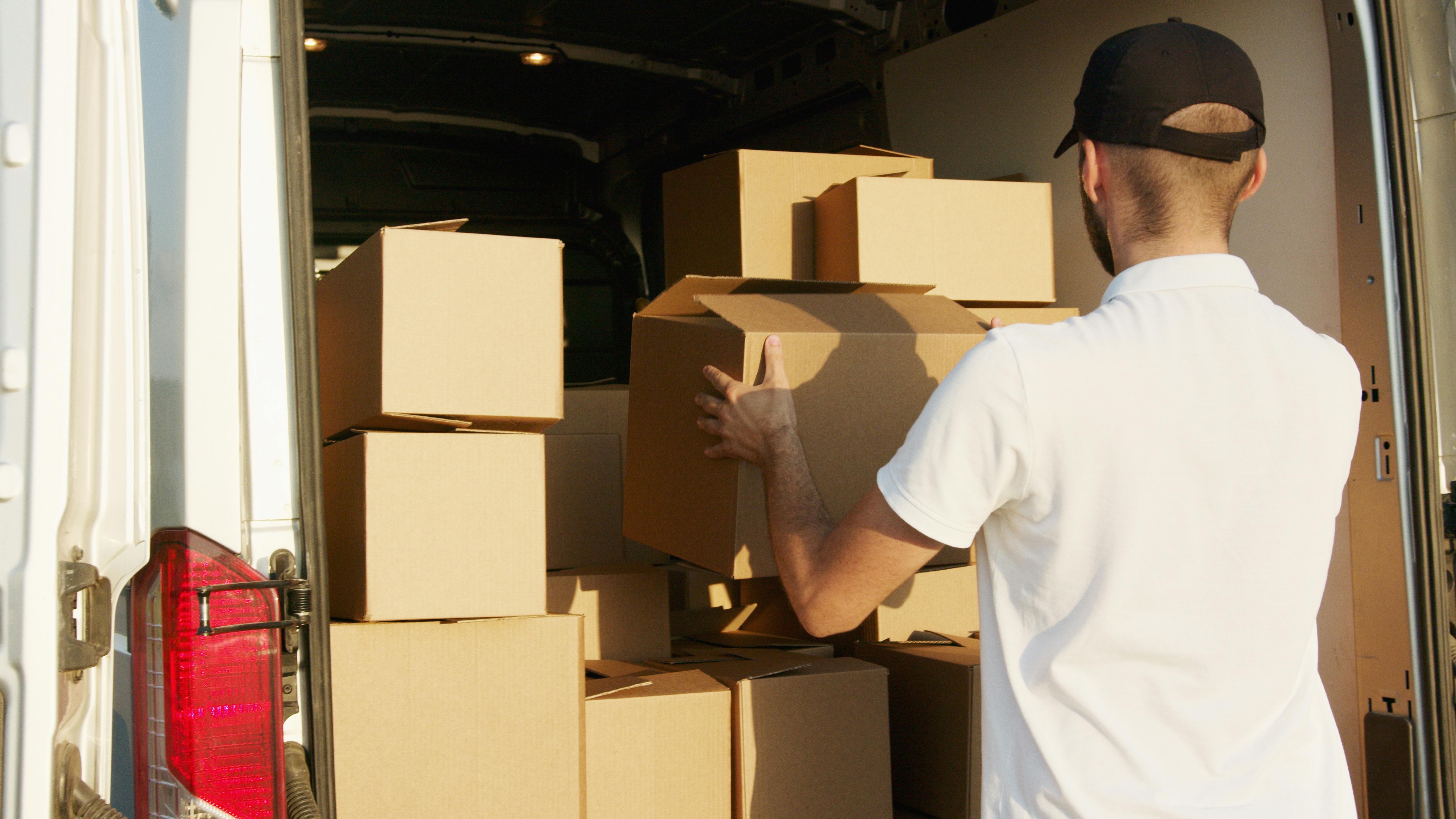 man stacking boxes in a van