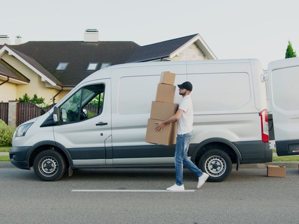 Livreur déchargeant des colis d'un utilitaire