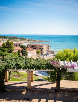 Explore Tarragona's vibrant seascape with Mediterranean architecture and lush greenery.