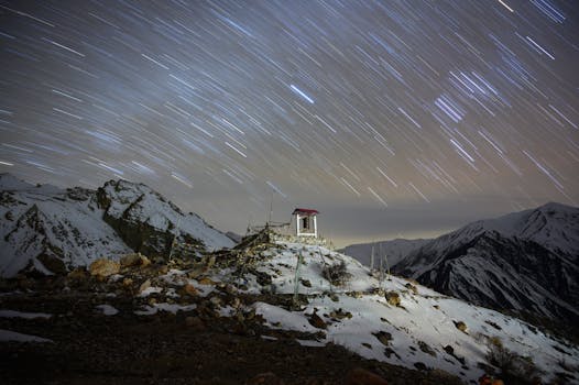 夜晚，在雪山上用长时间曝光拍摄星迹，山上有一座小寺庙