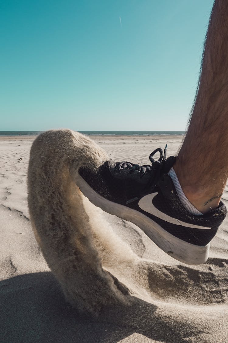 Close Up Of Man Foot Kicking The Sand