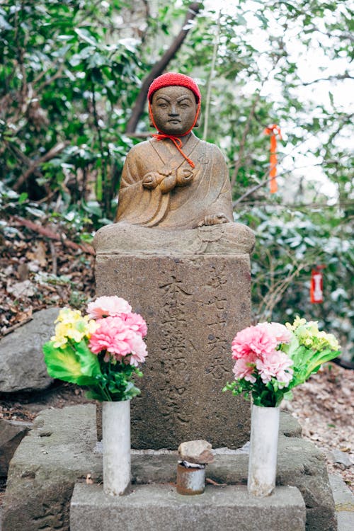 Stone Buddha Statue with Flowers in a Garden 