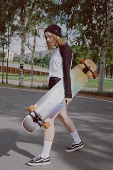 一位白人妇女在城市公园里拿着长板，享受着阳光明媚的户外时光