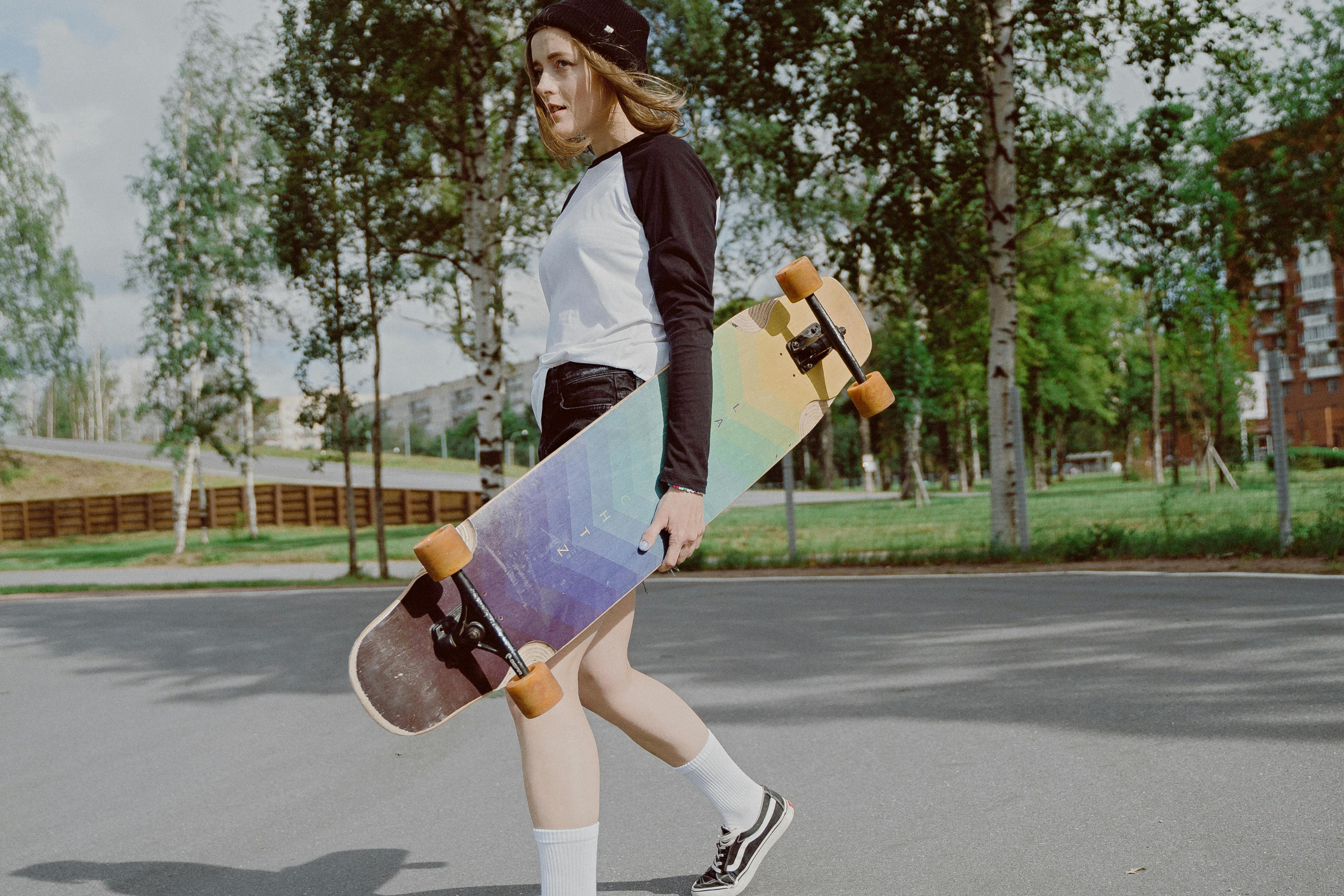 Fitness Girl In A White Top And Short Shorts Standing With A Skateboard On  Background Of A Concrete Wall Stock Photo, Picture and Royalty Free Image.  Image 123875242.