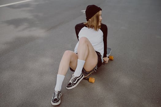 Casual scene of a woman sitting on a skateboard in an urban setting, embodying skate culture.