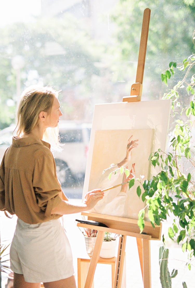 Blond Woman Painting Using Easel