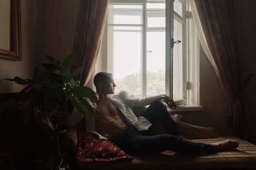 Man in White Shirt Sitting on Red Sofa Chair