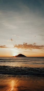 Peaceful sunset capturing vibrant colors over the ocean at Barra Guaratiba Beach, Brazil.