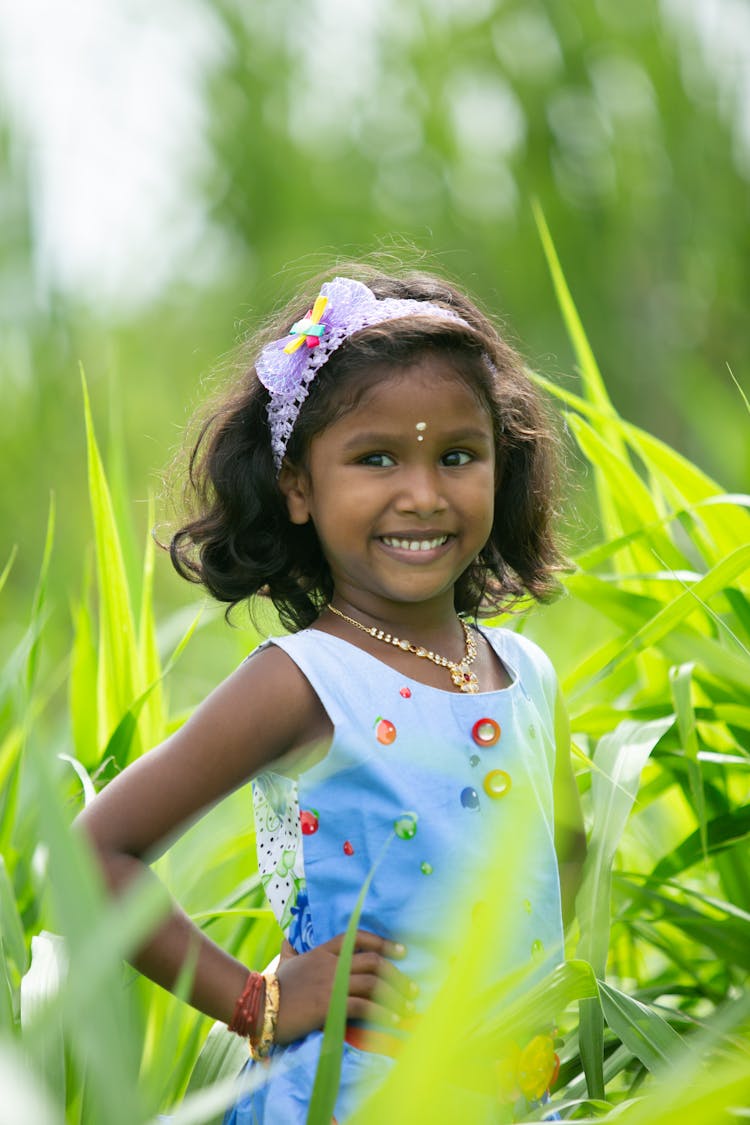 Smiling Girl Standing In Tall Grass