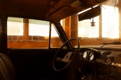 Free Interior of a vintage car basking in warm golden sunlight through windows. Stock Photo