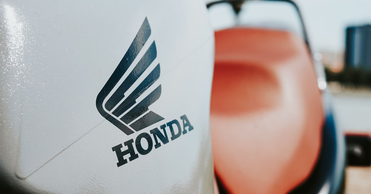 Detailed view of a Honda motorcycle logo on a sleek vehicle surface.