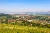 Explore a breathtaking aerial view of the verdant Niš countryside in Serbia, captured under a clear blue sky.