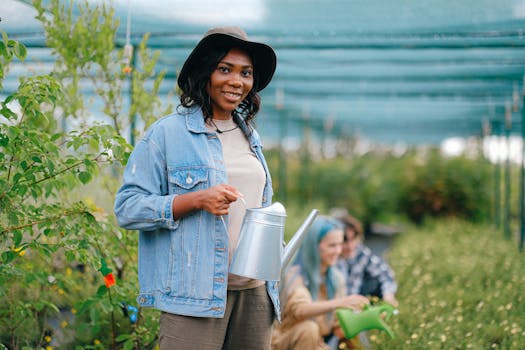 一位开朗的女人在温室里拿着喷壶，俯身照料植物