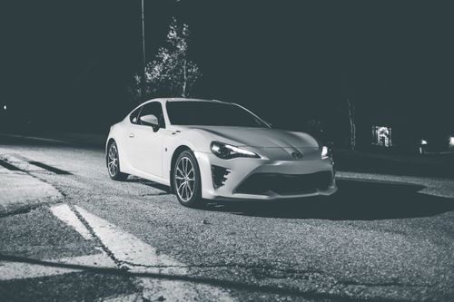 Free Black and white of coupe sport automobile on asphalt roadway late at night Stock Photo