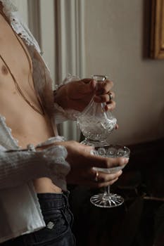 在精致的复古环境中，优雅地将葡萄酒从水晶瓶倒入玻璃杯