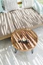 From above of long thin shadows on comfortable sofa and small round table in daytime