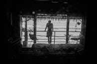 一个人从热带度假村房间的阳台上凝视着宁静的海洋