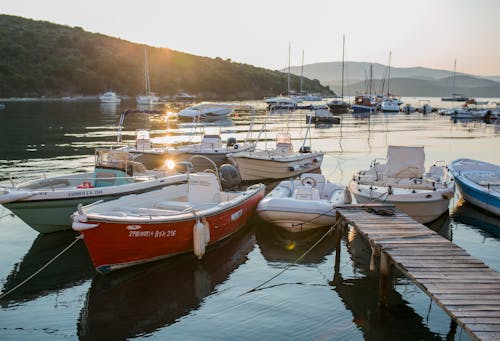 Moored boats and wooden pier in sunset