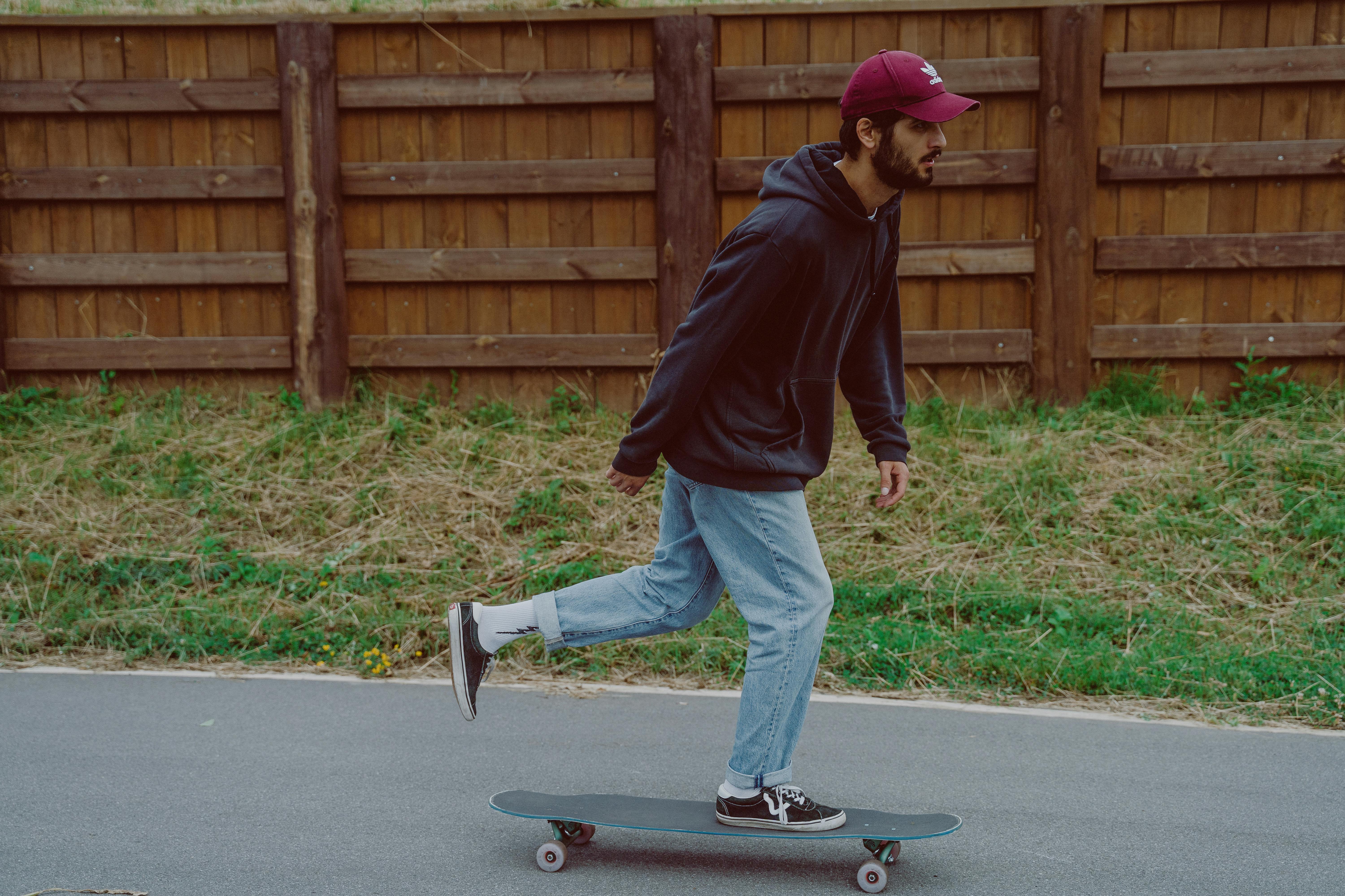 man in black hoodie jacket riding skateboard