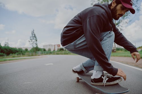 Gratis Pria Dengan Jaket Coklat Dan Jeans Denim Biru Duduk Di Jalan Aspal Abu Abu Foto Stok