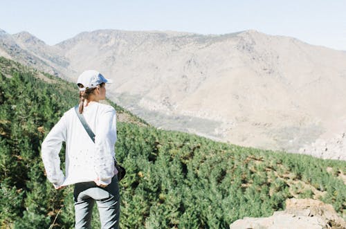 Female traveler on high hillside in mountains