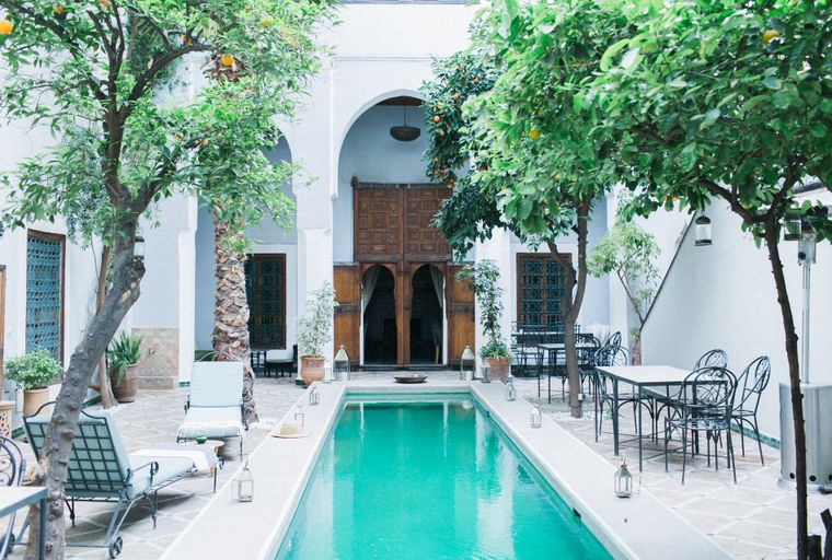 Courtyard pool and carved timber doors at the garden house — photo by Evgenia Basyrova on Pexels