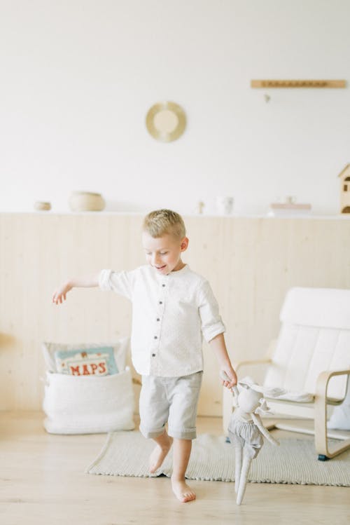 Boy in White Dress Shirt and Blue Denim Jeans Standing on White Plastic Container