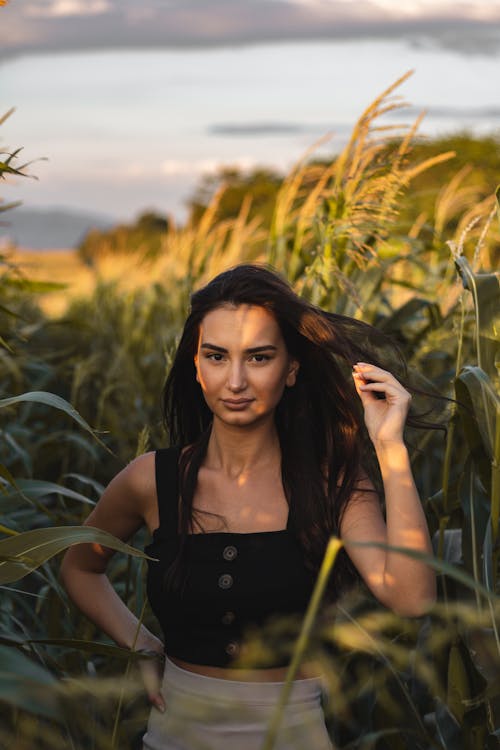 Woman in Black Tank Top Standing on Corn Field