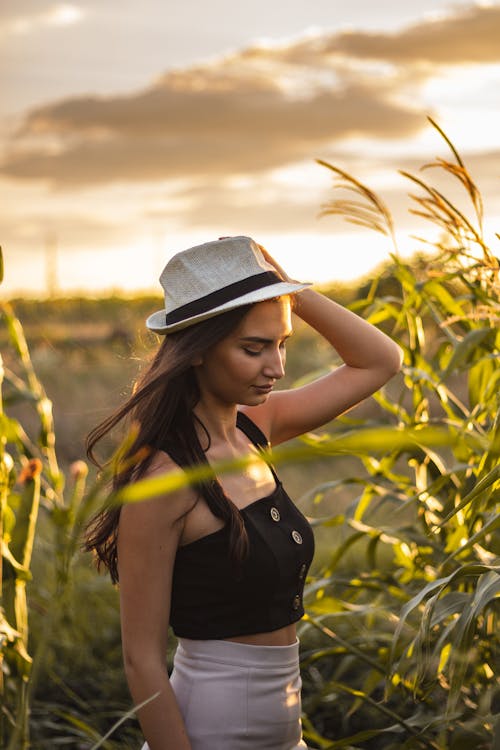 Woman Wearing a Fedora Hat Standing at the Field