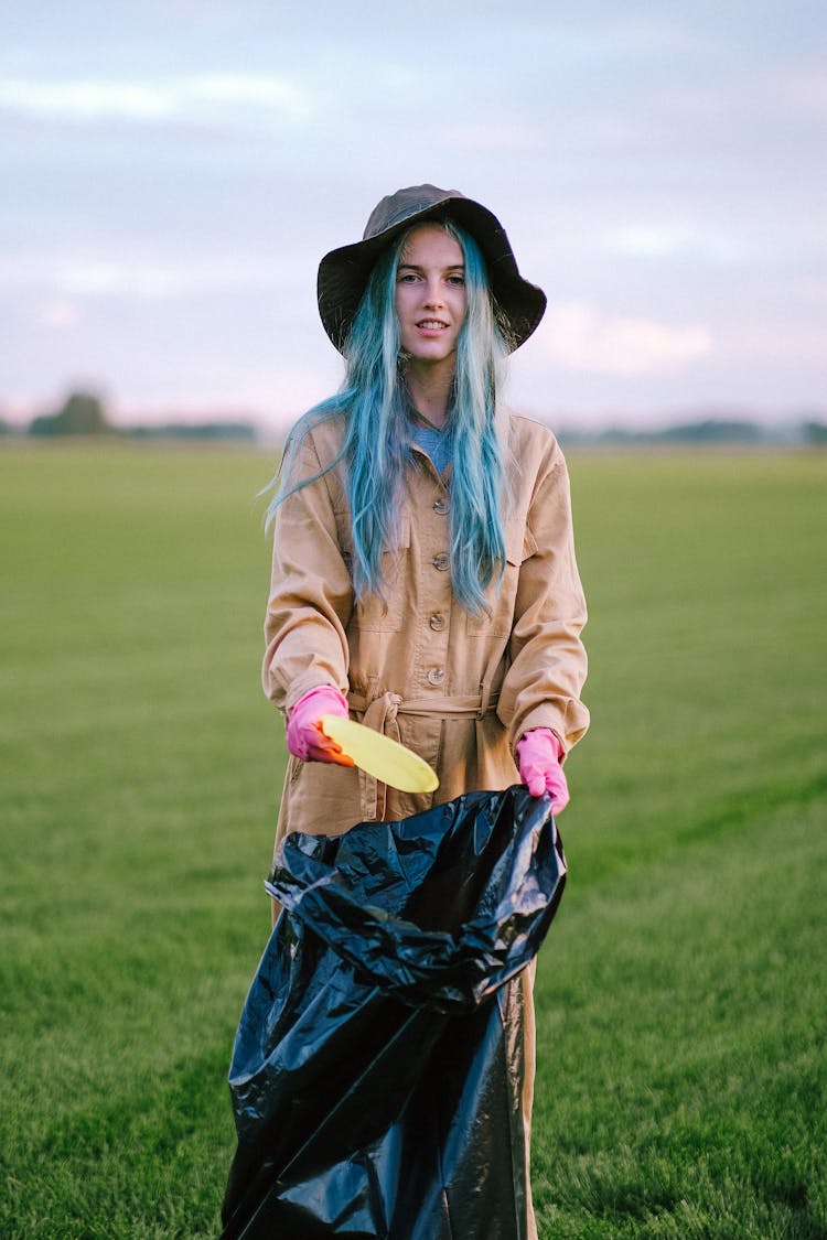 A Woman Putting Trash In A Garbage Bag