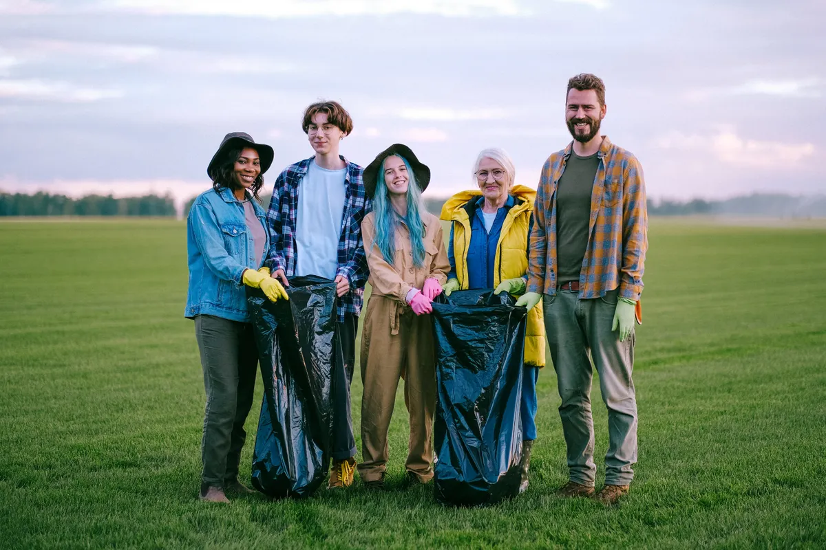 A team of volunteers gathered together outdoors, smiling at the camera