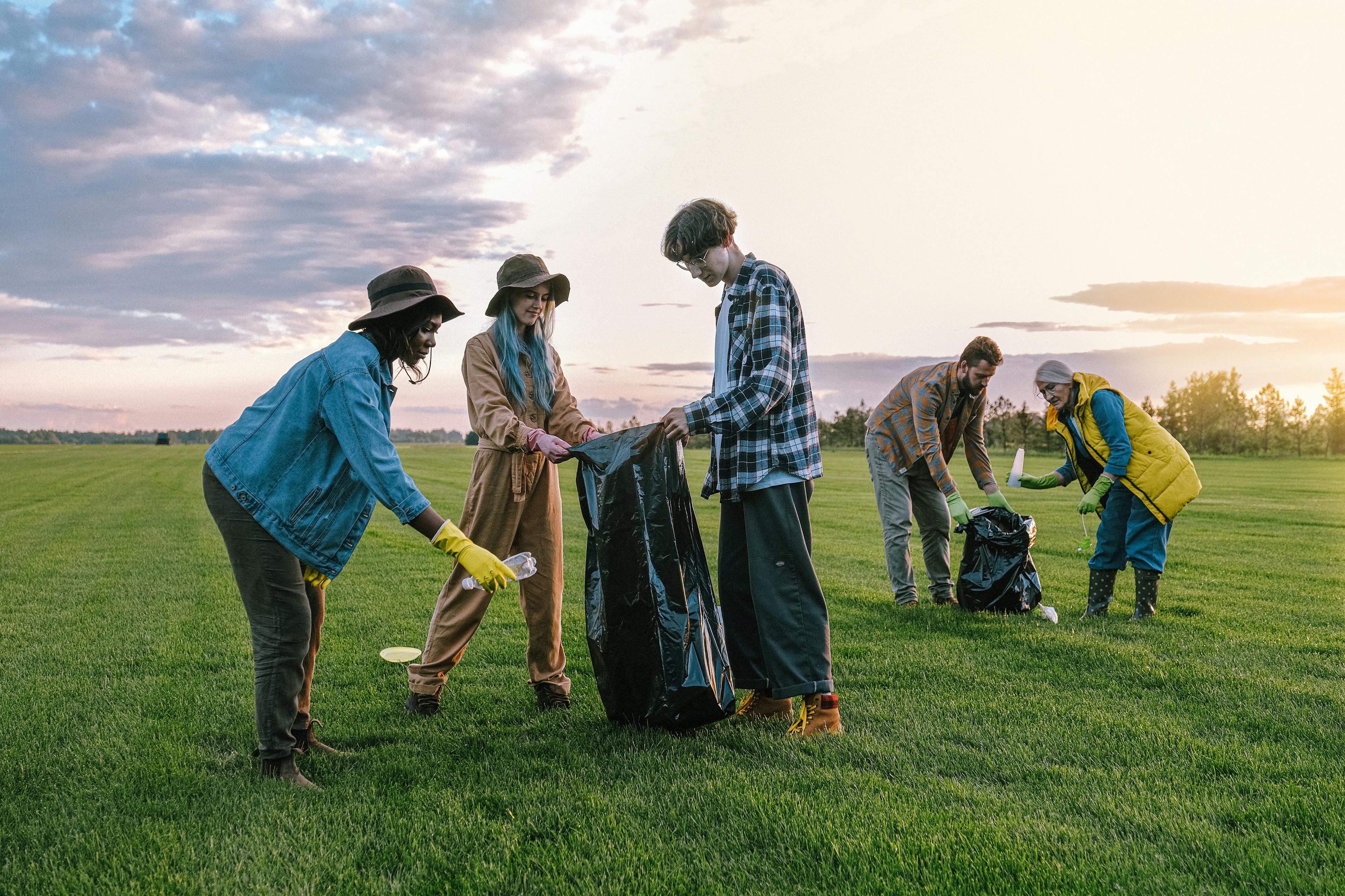 Volunteers Collecting Trash on Green Grass Field