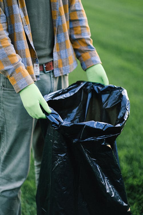 A Person Holding Black Garbage Bag