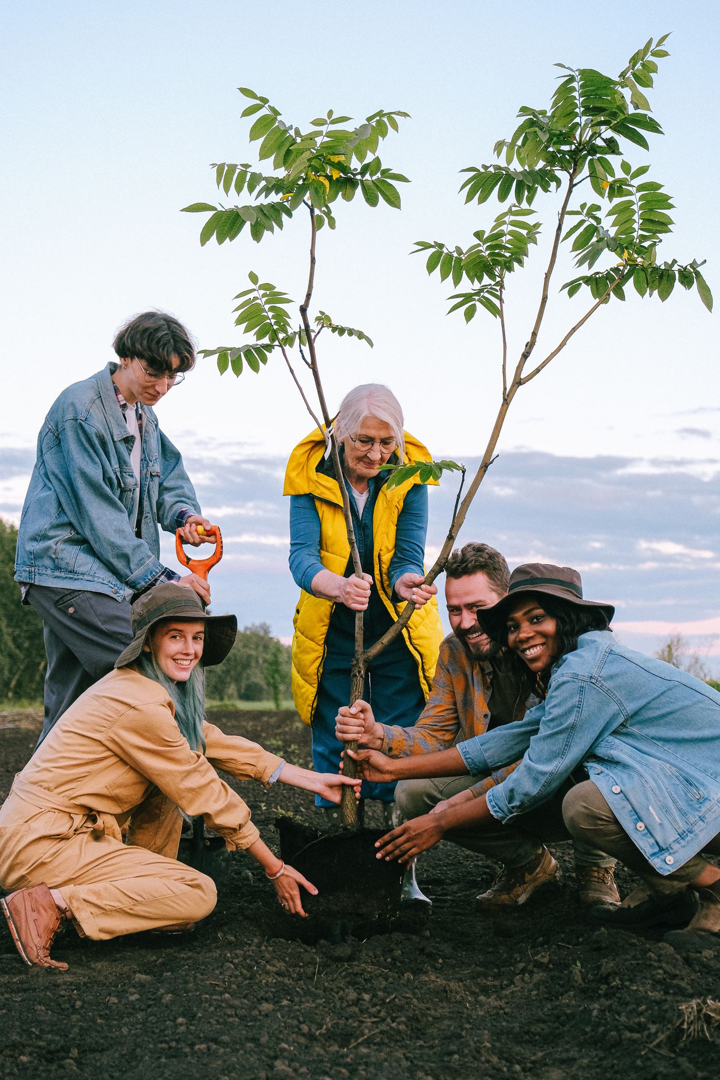 A diverse group volunteering together outdoors in a community setting